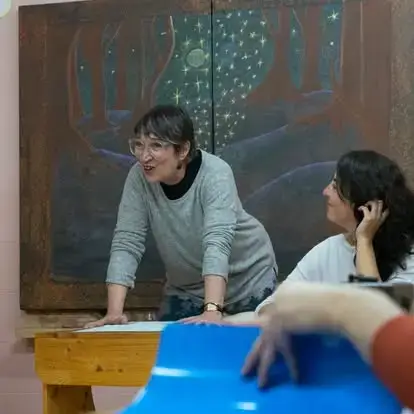 Mujer sonriendo en escritorio con fondo artistico