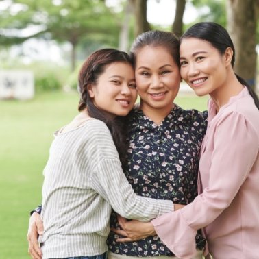 Familia de mujeres asiáticas sonriendo abrazadas